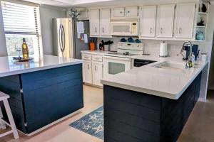 a large kitchen with white cabinets and a blue island at Saida Towers II #506 condo in South Padre Island