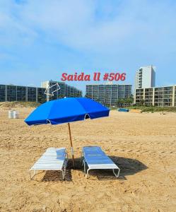 two chairs and an umbrella on a beach at Saida Towers II #506 condo in South Padre Island