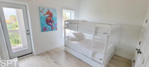 サウス・パドレ・アイランドにあるPadre Beach House homeの窓付きの客室の白い二段ベッド1台分です。 +209枚の写真