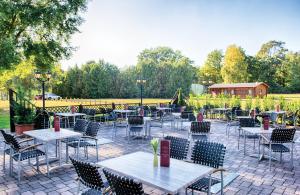 an outdoor patio with tables and chairs at Leonardo Hotel Köln Bonn Airport in Cologne