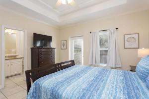 Un dormitorio con una cama, una cómoda y un televisor. en Dom's Beach Retreat home, en South Padre Island