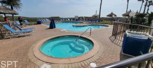 a swimming pool in a resort with blue chairs at Saida Towers IV #108 condo in South Padre Island +100 photos