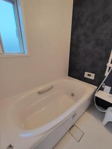 a white bath tub in a bathroom with a window at Seaside House Cozy - Vacation STAY 03320v in Sammu