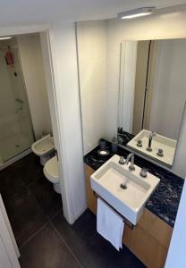 a bathroom with a sink and a toilet and a mirror at Puerto del Águila Departamento con vista al lago- The View Luxuary Aparts in Potrero de Garay