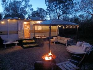 a tent and a fire in a yard next to a caravan at Back Beach Beryl Ocean Bay Getaway PL in Fingal +14 photos