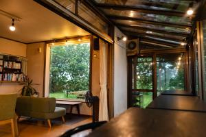 a living room with a window and a table and a chair at Akane-yado in Nakafurano