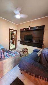 une chambre avec un lit et une télévision à écran plat dans l'établissement Casa Estilosa, à Casa Branca