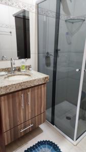 une salle de bain avec une douche, un lavabo et un miroir dans l'établissement Casa Estilosa, à Casa Branca