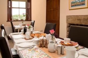 - une salle à manger avec une table et de la nourriture dans l'établissement Stanley Lodge Farmhouse, à Cockerham
