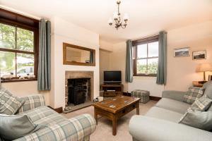 a living room with two couches and a tv at Stanley Lodge Farmhouse in Cockerham