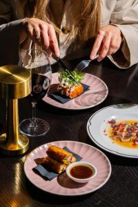 a woman eating food on a table with plates of food at Kimpton Margot Sydney by IHG in Sydney +185 photos