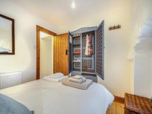 a bedroom with a bed with two towels at The Holly Tree Cottage in Rashfield +7 photos