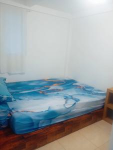 a bed with a blue blanket on top of it at villa omah citeko 2 in Tagalbato