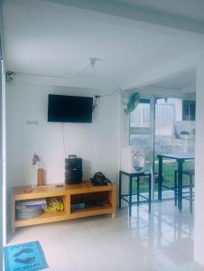 a living room with a table and a tv on a wall at villa omah citeko 2 in Tagalbato