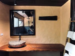 a bathroom with a stone sink and a mirror at Cọ Retreat Da Bac in Hòa Bình