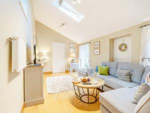 a living room with a blue couch and a table at Benchmark Cottage in Glaisdale