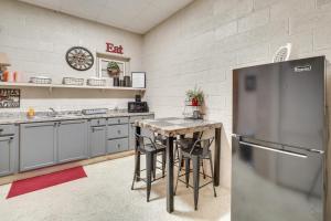 a kitchen with a refrigerator and a table with stools at The Boiler Room - ATV-Friendly Briceville Gem! in Briceville