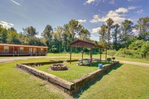 un patio trasero con una hoguera y un edificio en ATV Adventures Await Tennessee Riverside Retreat, en Briceville