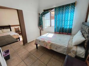 a small room with a bed and a window at Casa del Patrón Posada in Taxco de Alarcón