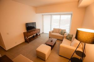 a living room with a couch and a tv at Indico in Mérida