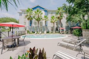 a swimming pool with tables and chairs and a building at Holiday Inn Express Hotel & Suites Charleston-Ashley Phosphate by IHG in Charleston