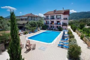 an apartment with a swimming pool in front of a building at Christina Studios in Lygia