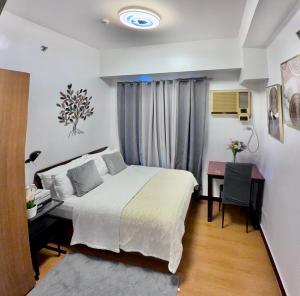 a hotel room with a bed and a desk and a desk at 1 Bedroom Bayview Condo near SLMEC & US Embassy in Manila +12 photos