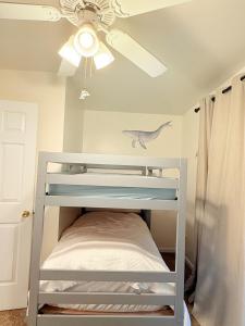 a white bunk bed in a room with a ceiling fan at Surfside Beach Haven in Surf City