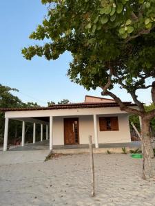 a small house with a tree in front of it at Casa Pôr do Sol in Guriú