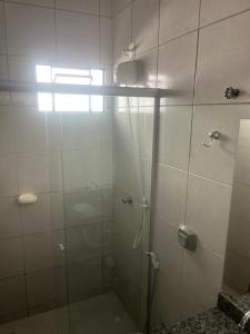 a shower with a glass door in a bathroom at Casa Progresso de Anápolis in Anápolis