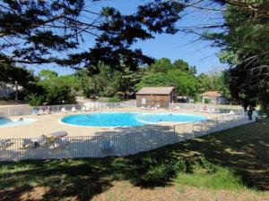 ein großes Schwimmbecken mit Menschen, die darum herum sitzen in der Unterkunft Appartement avec Terrasse pour 4 personnes à Saint-Georges-d'Oléron - API-1-52-630 in Saint-Georges-dʼOléron + 12 Fotos
