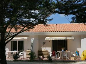 ein Haus mit einem Tisch und Stühlen davor in der Unterkunft Appartement avec Terrasse pour 4 personnes à Saint-Georges-d'Oléron - API-1-52-630 in Saint-Georges-dʼOléron