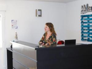 Eine Frau, die an einer Theke in einem Büro steht. in der Unterkunft Appartement avec Terrasse pour 4 personnes à Saint-Georges-d'Oléron - API-1-52-630 in Saint-Georges-dʼOléron