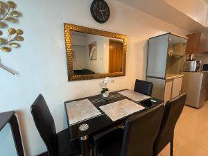 a dining room table with chairs and a mirror at 1 Bedroom Bayview Condo near SLMEC & US Embassy in Manila
