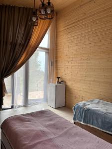 Un dormitorio con una cama y una ventana grande. en Jargylchak-Sunrise, en Kichi-Jargylchak