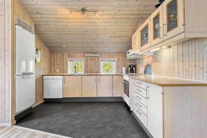 a large kitchen with wooden walls and wooden counters at C11307-Tarm-Rorsangervaenget-1 in Tarm