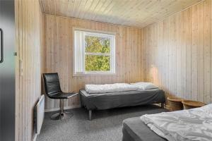 a bedroom with a bed and a chair and a window at C11307-Tarm-Rorsangervaenget-1 in Tarm
