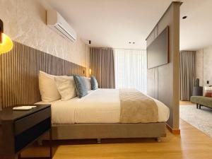 a bedroom with a large bed and a television at Exclusive Studio El poblado in Medellín