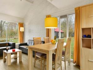 a dining room and living room with a table and chairs at Wooded Park Retreat in Drenthe in Midlaren