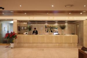 a man standing at a counter in a lobby at Seoul Rex Hotel in Seoul
