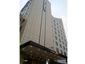 a tall white building with a sign on it at Seoul Rex Hotel in Seoul