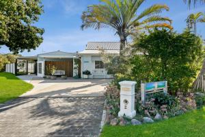 una casa con una palmera y un jardín en Funky Lil Shack - by the jetty, en Bongaree