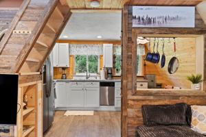 a kitchen in a tiny house with wooden walls at A-Frame At Entrance to Rainier- Hot Tub & WiFi in Ashford +11 photos