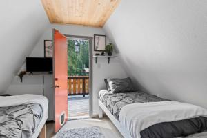 a room with two beds and a door to a balcony at A-Frame At Entrance to Rainier- Hot Tub & WiFi in Ashford