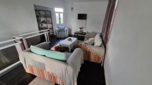 ein Wohnzimmer mit zwei Sofas und einem Tisch in der Unterkunft Résidence La Montagne in Saint Gabriel