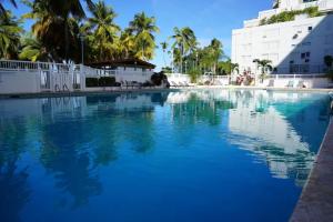 a large pool with blue water in front of a building at Stylish Beach Condo ,1BR , City View Escape in San Juan