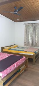 2 letti in una camera con soffitto di His Grace Holiday Home - Nr to Malpe Beach a Udupi