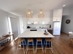 a kitchen with a table with chairs and a counter top at Driftwood Beach House - Coastal Haven North Beach in Wallaroo +10 photos