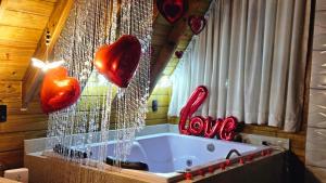 a bathroom with red hearts hanging from a tub at Sítio Família Cherba-Cabana Pôr do Sol in Videira