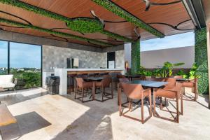 cocina al aire libre y zona de comedor con mesas y sillas en Vibra Bonito - Boho Chic Studio with Rooftop & Infinite Pool, en Tulum